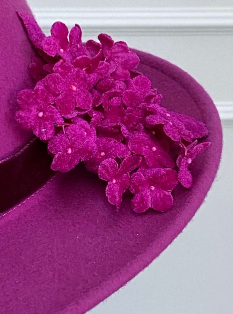 IMG_1922 Close-up of a pink felt hat with a cluster of fabric flowers on the brim. | Sarah Ross Millinery