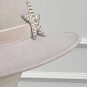 A beige hat with a wide brim features a silver and black star-shaped brooch on the band. | Sarah Ross Millinery