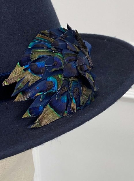 IMG_1944 A dark blue hat with a band, featuring decorative blue and green peacock feathers on the side. | Sarah Ross Millinery